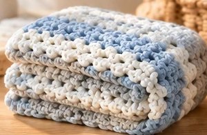 Baby Blue palette: a folded striped crochet baby blanket in baby blue, cream and grey.